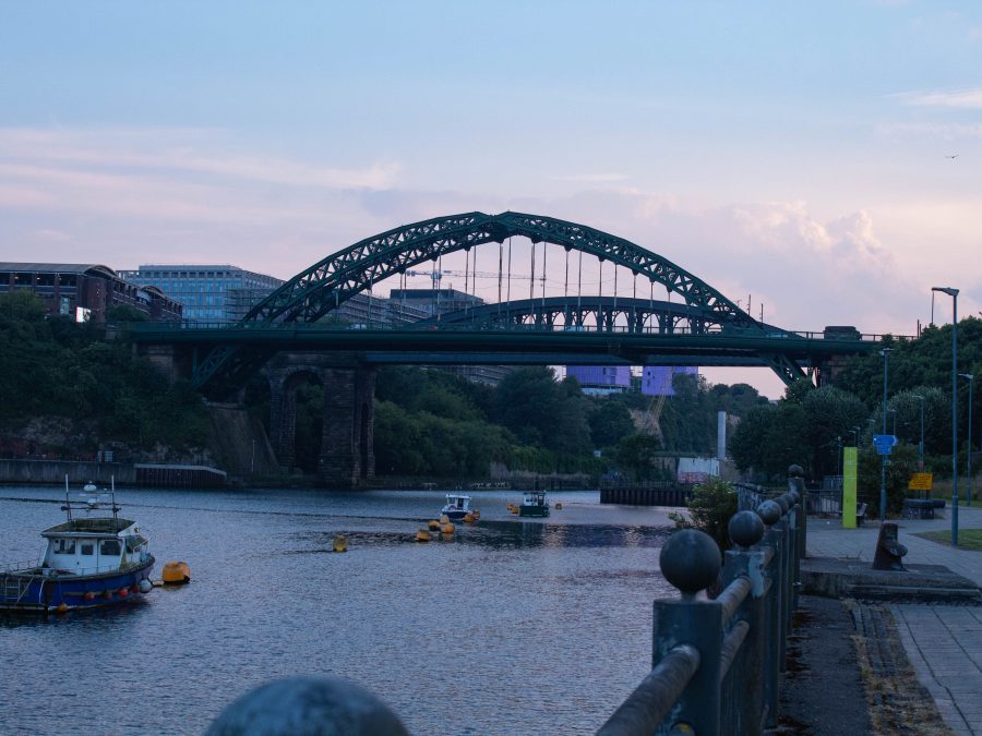 Image of the Tyne river, including the Tyne Bridge and boats. The Glasshouse can be seen in the background.