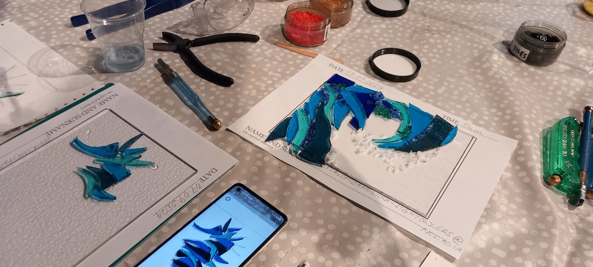 A table full of fused glass arts from a creative health workshop